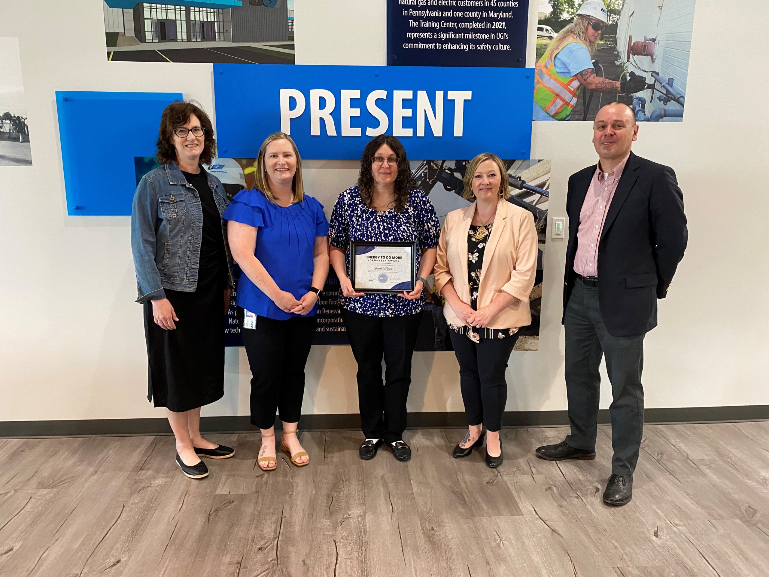 UGI employees stand and smile with award winner.