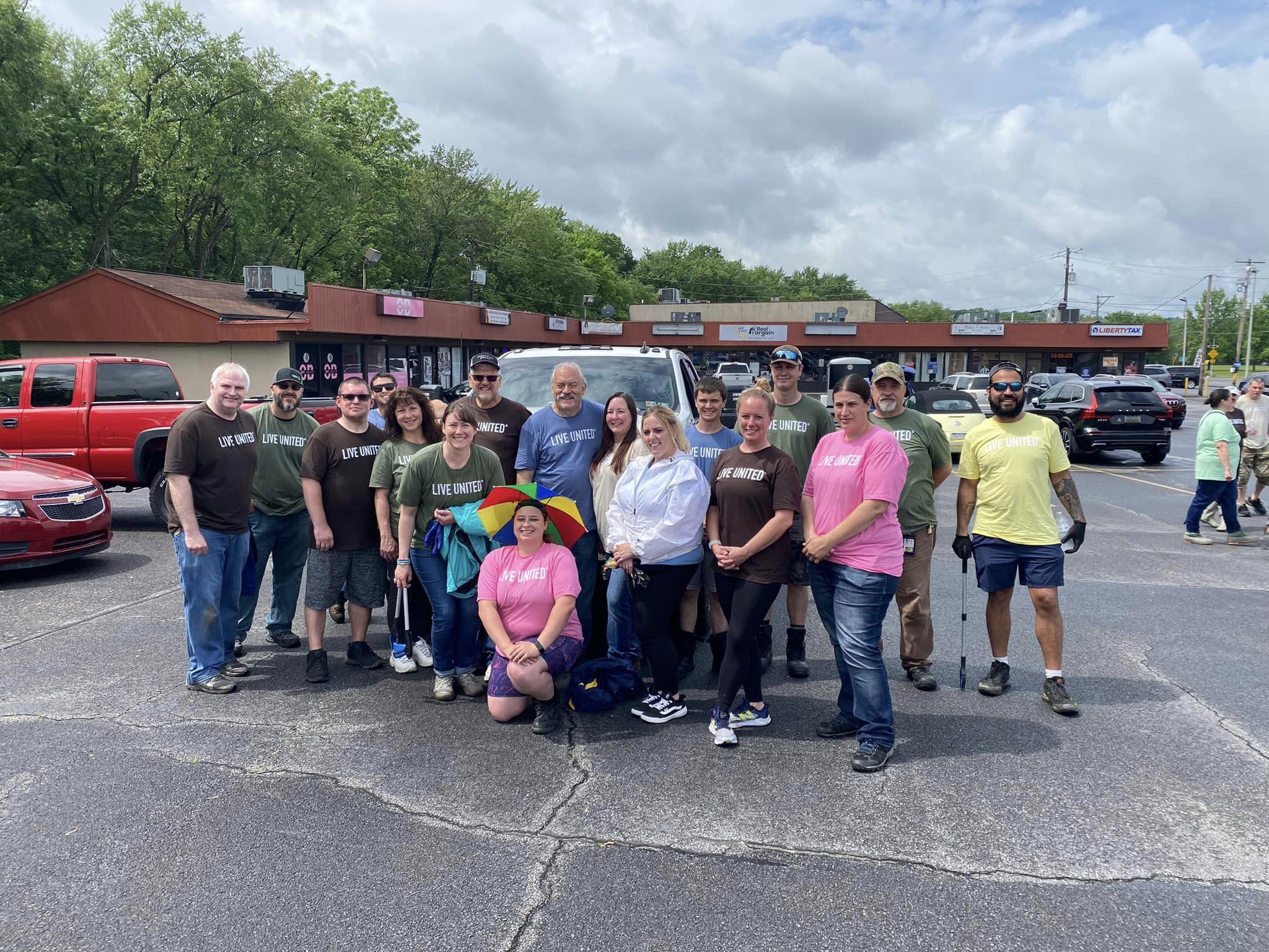 UGI employees stand together in parking lot with trash picking tools.