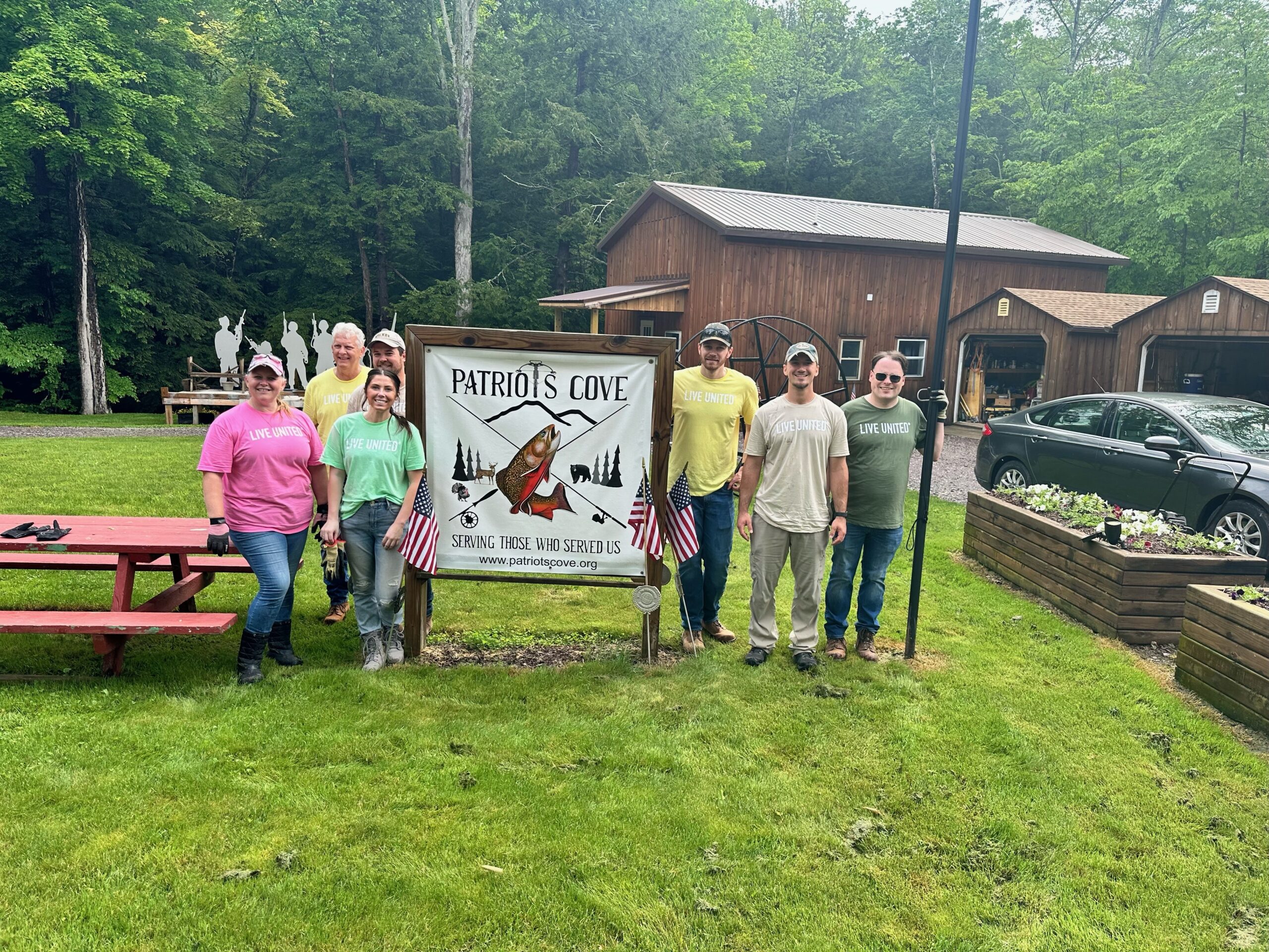 UGI employees stand next to Patriots Cove sign.