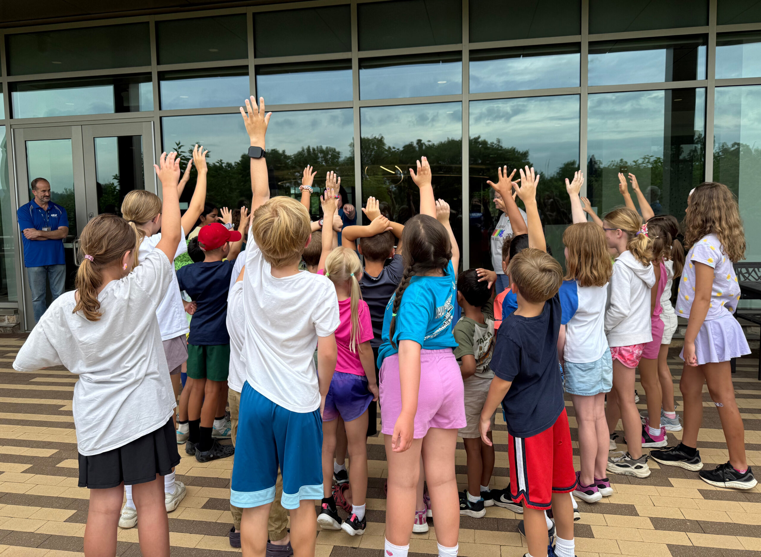 Students raise their hands to participate in a watershed activity.